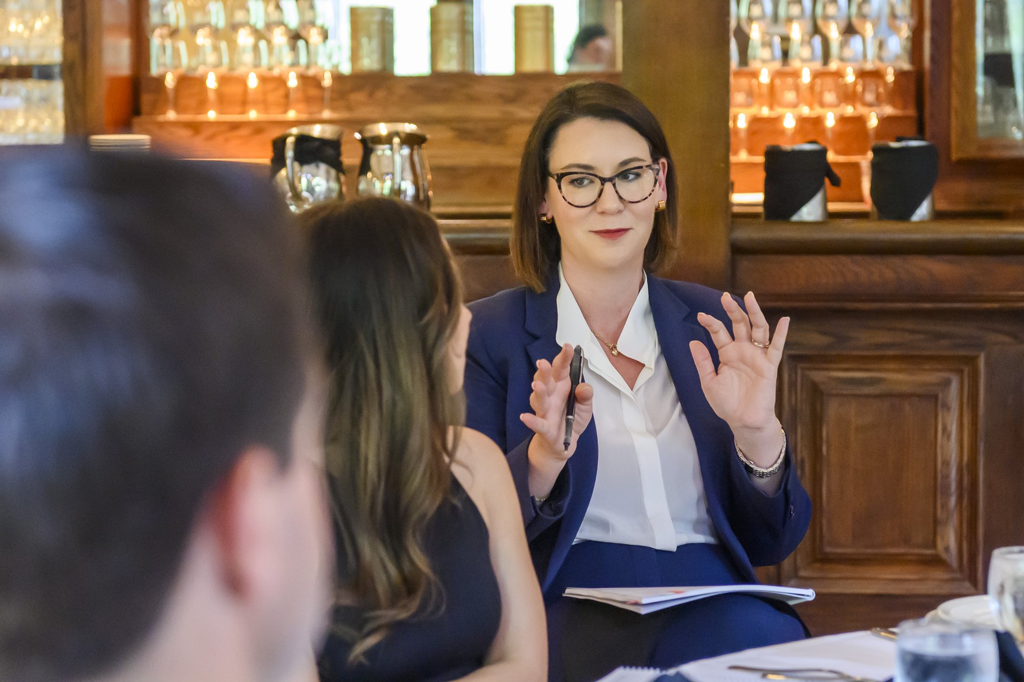 Kara Smith Brown leading a workshop discussion at a dinner table